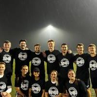 Students wearing championship shirts from a coed flag football tournament